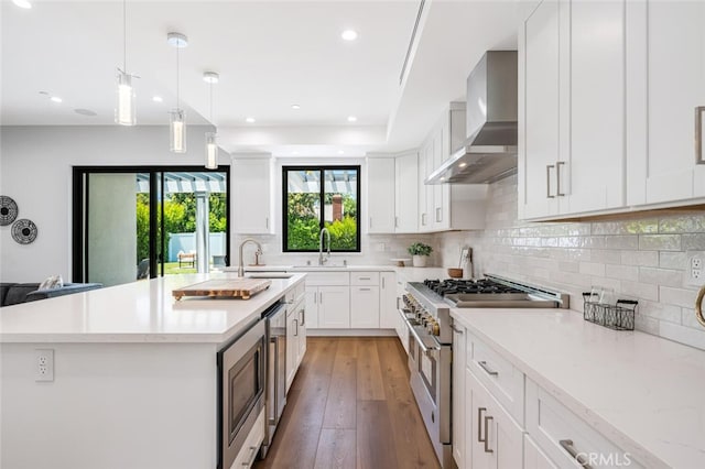 251 S Griffith Park Dr, Burbank, CA 91506 - kitchen featuring wall chimney exhaust hood, appliances with stainless steel finishes, light wood-type flooring, decorative backsplash, and white cabinetry