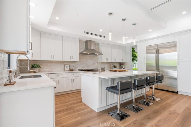 251 S Griffith Park Dr, Burbank, CA 91506 - kitchen with wall chimney exhaust hood, built in refrigerator, a center island with sink, a kitchen breakfast bar, and backsplash