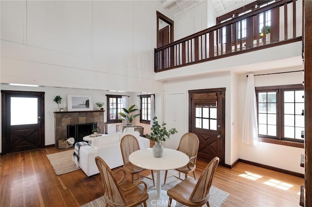 525 Manhattan Beach Blvd, Manhattan Beach, CA 90266 - dining space featuring light wood-style flooring, a towering ceiling, a tile fireplace, and healthy amount of natural light