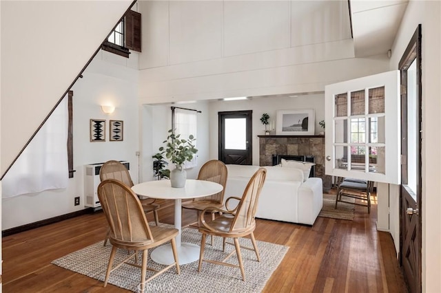 525 Manhattan Beach Blvd, Manhattan Beach, CA 90266 - dining space featuring wood-type flooring, a tile fireplace, a towering ceiling, and radiator heating unit
