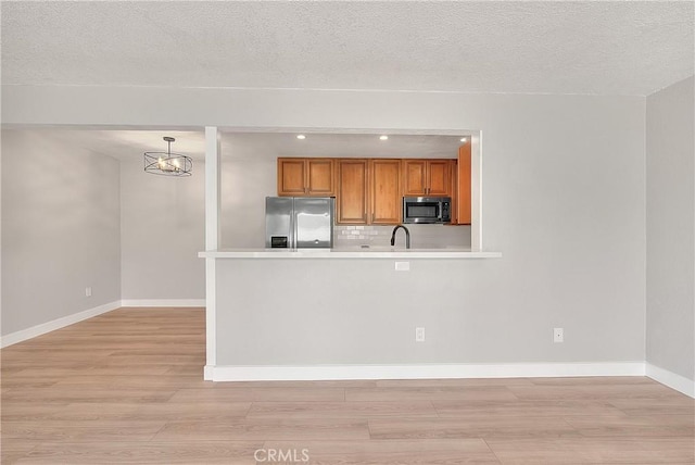 3096 Panorama Rd Unit A, Riverside, CA 92506 - kitchen featuring appliances with stainless steel finishes, brown cabinetry, light countertops, light wood-style flooring, and recessed lighting