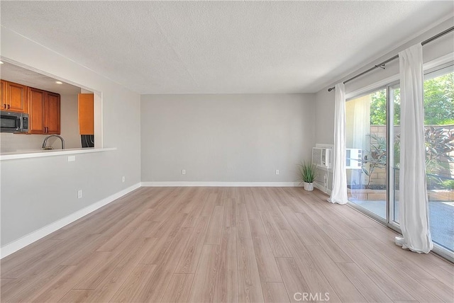 3096 Panorama Rd Unit A, Riverside, CA 92506 - unfurnished living room with a textured ceiling and light wood-style floors