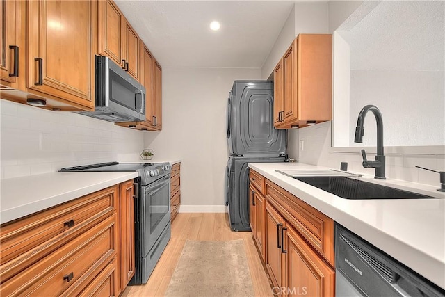 3096 Panorama Rd Unit A, Riverside, CA 92506 - kitchen featuring stainless steel appliances, stacked washer / dryer, light wood-style flooring, backsplash, and light countertops