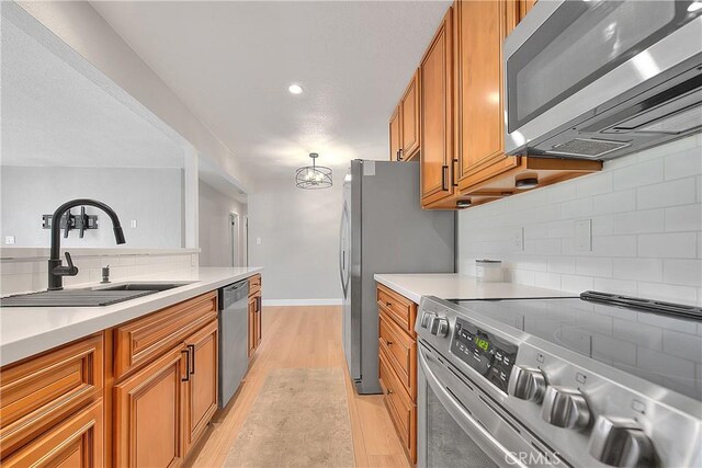 3096 Panorama Rd Unit A, Riverside, CA 92506 - kitchen featuring appliances with stainless steel finishes, brown cabinetry, light wood-type flooring, backsplash, and recessed lighting