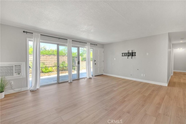 3096 Panorama Rd Unit A, Riverside, CA 92506 - spare room with a textured ceiling, light wood-style floors, and an AC wall unit