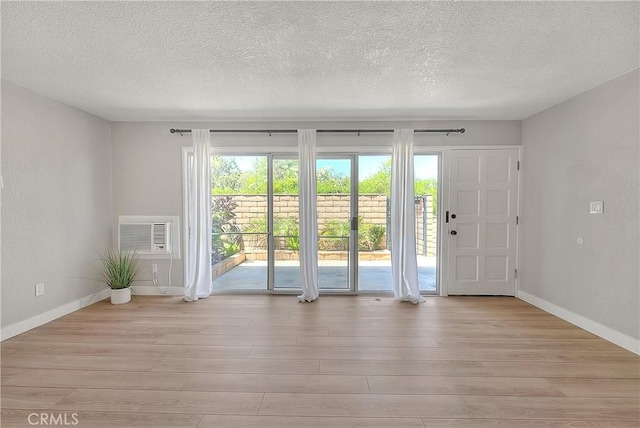 3096 Panorama Rd Unit A, Riverside, CA 92506 - foyer entrance featuring wood finished floors, a textured ceiling, and an AC wall unit