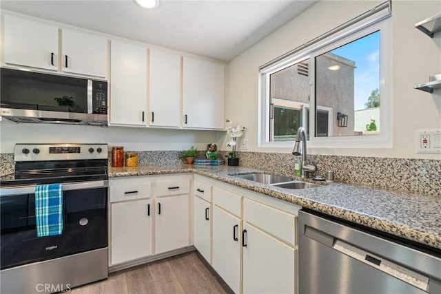 3066 Via Serena S Unit A, Laguna Woods, CA 92637 - kitchen with stainless steel appliances, wood finished floors, white cabinetry, light stone counters, and recessed lighting