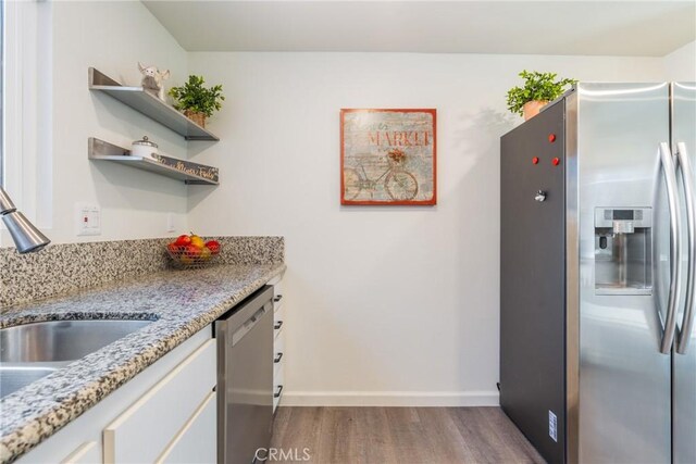 3066 Via Serena S Unit A, Laguna Woods, CA 92637 - kitchen featuring stainless steel appliances, dark wood-style floors, open shelves, light stone counters, and white cabinetry