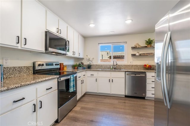 3066 Via Serena S Unit A, Laguna Woods, CA 92637 - kitchen with stainless steel appliances, wood finished floors, white cabinets, light stone countertops, and recessed lighting
