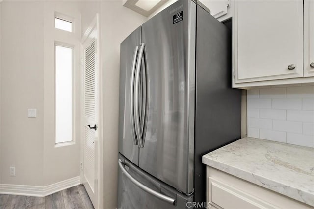 17202 Corbina Ln Unit 208, Huntington Beach, CA 92649 - kitchen featuring freestanding refrigerator, wood finished floors, decorative backsplash, light stone counters, and white cabinets