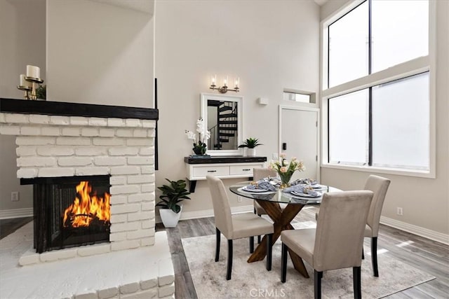 17202 Corbina Ln Unit 208, Huntington Beach, CA 92649 - dining room with wood finished floors, a high ceiling, and a fireplace
