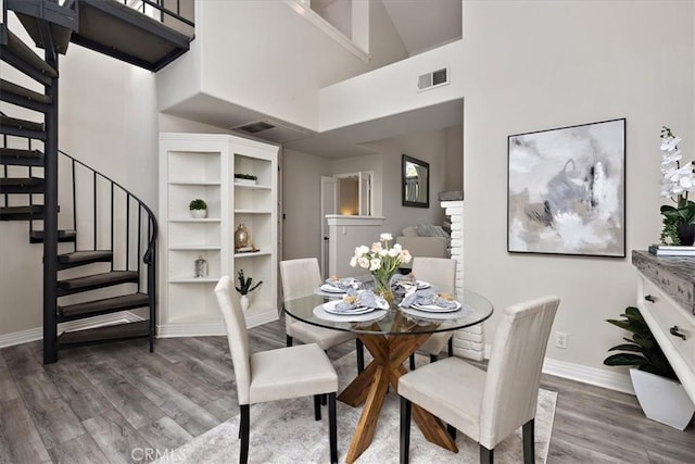 17202 Corbina Ln Unit 208, Huntington Beach, CA 92649 - dining space with stairway, wood finished floors, and a towering ceiling