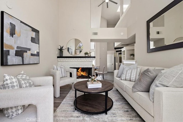 17202 Corbina Ln Unit 208, Huntington Beach, CA 92649 - living room featuring ceiling fan, wood finished floors, a fireplace, a high ceiling, and built in shelves