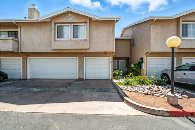 1465 E Lexington Ave Unit 4C, El Cajon, CA 92019 - view of property featuring driveway, a garage, and stucco siding