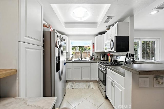 1465 E Lexington Ave Unit 4C, El Cajon, CA 92019 - kitchen with appliances with stainless steel finishes, healthy amount of natural light, light tile patterned floors, a raised ceiling, and recessed lighting