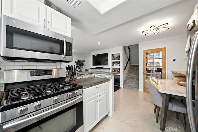 1465 E Lexington Ave Unit 4C, El Cajon, CA 92019 - kitchen featuring stainless steel appliances, light tile patterned floors, white cabinets, dark countertops, and recessed lighting