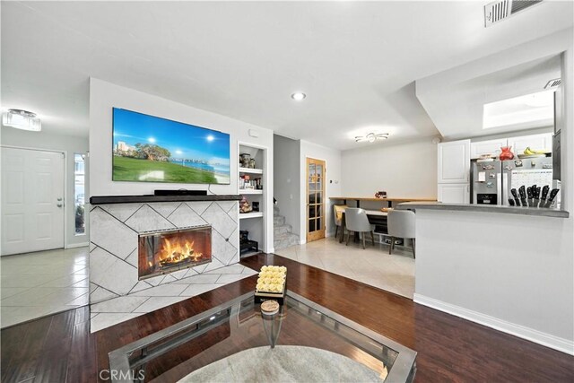 1465 E Lexington Ave Unit 4C, El Cajon, CA 92019 - living area featuring built in shelves, a tiled fireplace, wood finished floors, and recessed lighting