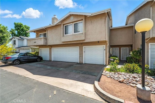 1465 E Lexington Ave Unit 4C, El Cajon, CA 92019 - view of property with driveway, stucco siding, a garage, and a chimney
