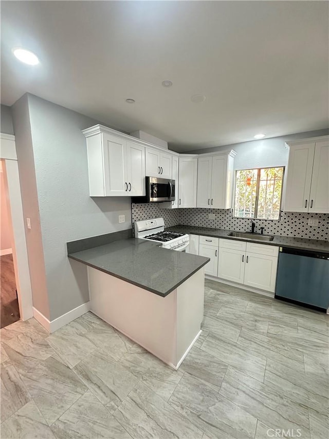 696 E 51st St E, Los Angeles, CA 90011 - kitchen with white range with gas stovetop, dishwashing machine, stainless steel microwave, decorative backsplash, and dark countertops