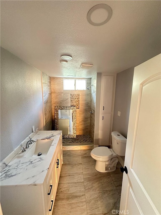 696 E 51st St E, Los Angeles, CA 90011 - full bathroom with tiled shower, vanity, a textured ceiling, and a textured wall