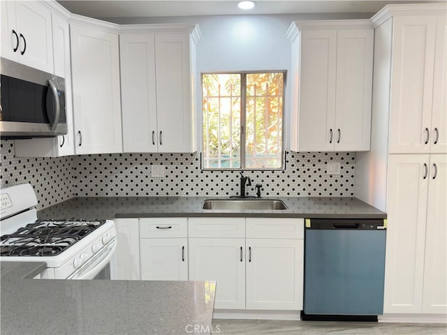 696 E 51st St E, Los Angeles, CA 90011 - kitchen featuring dishwasher, stainless steel microwave, white range with gas cooktop, tasteful backsplash, and white cabinetry
