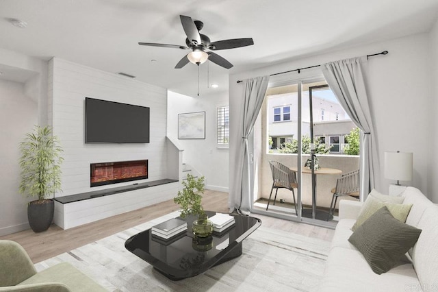 5140 Calle Sand Arch Unit 61, San Diego, CA 92154 - living room featuring wood finished floors, a glass covered fireplace, and a ceiling fan