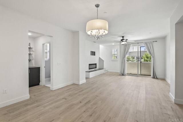 5140 Calle Sand Arch Unit 61, San Diego, CA 92154 - unfurnished living room featuring light wood-style flooring, ceiling fan, a chandelier, and a large fireplace