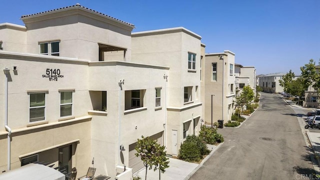 5140 Calle Sand Arch Unit 61, San Diego, CA 92154 - view of property featuring an attached garage and driveway