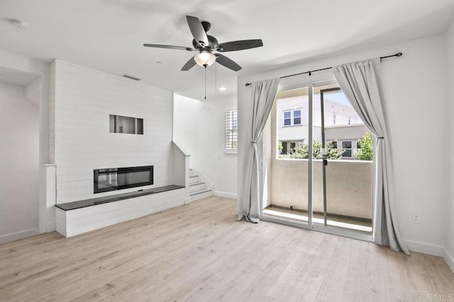 5140 Calle Sand Arch Unit 61, San Diego, CA 92154 - unfurnished living room with a fireplace, wood finished floors, ceiling fan, and stairs