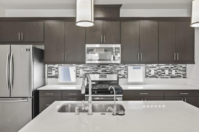 5140 Calle Sand Arch Unit 61, San Diego, CA 92154 - kitchen with appliances with stainless steel finishes, light countertops, dark brown cabinets, and backsplash