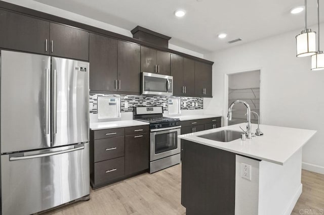 5140 Calle Sand Arch Unit 61, San Diego, CA 92154 - kitchen featuring appliances with stainless steel finishes, light countertops, light wood-style floors, decorative backsplash, and decorative light fixtures