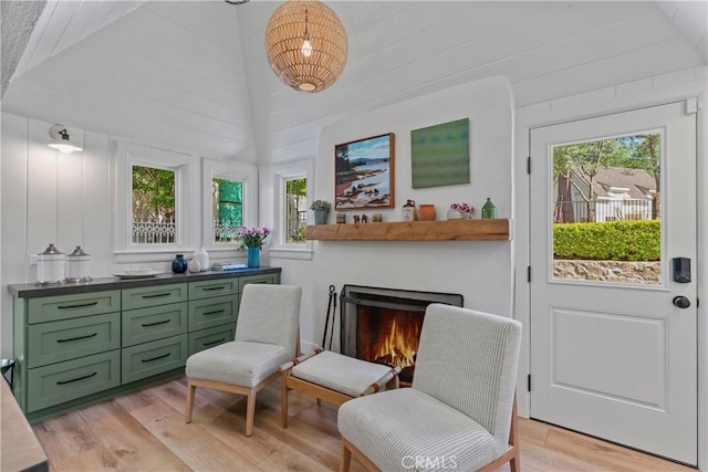 28233 N Shore Rd, Lake Arrowhead, CA 92352 - living area with light wood-style flooring, vaulted ceiling, and a lit fireplace