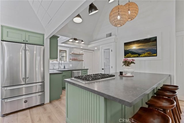 28233 N Shore Rd, Lake Arrowhead, CA 92352 - kitchen featuring green cabinets, stainless steel appliances, vaulted ceiling, light wood-type flooring, and dark countertops