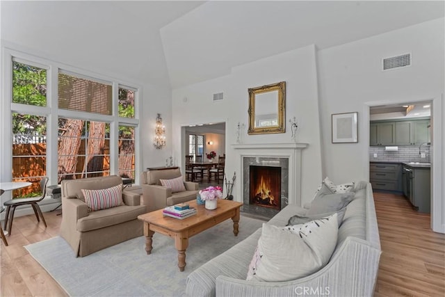 28233 N Shore Rd, Lake Arrowhead, CA 92352 - living room featuring high vaulted ceiling, light wood finished floors, and a premium fireplace