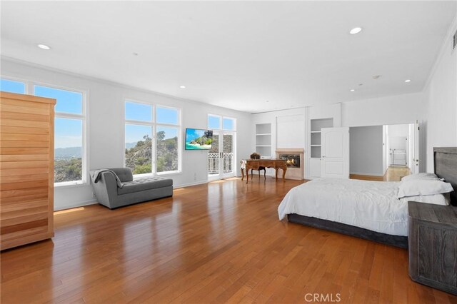 759 Foxkirk Rd, Glendale, CA 91206 - bedroom featuring wood finished floors, recessed lighting, a glass covered fireplace, and access to outside