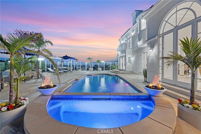 759 Foxkirk Rd, Glendale, CA 91206 - pool at dusk with an outdoor fire pit, an outdoor pool, a patio, and an in-ground hot tub