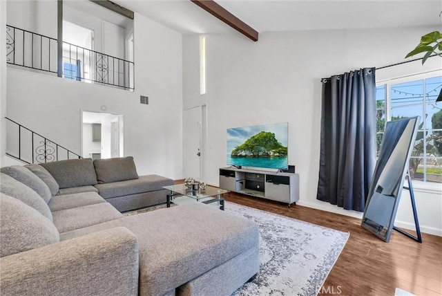 5005 Pearblossom Dr, Riverside, CA 92507 - living room featuring wood finished floors, beamed ceiling, a towering ceiling, and stairway