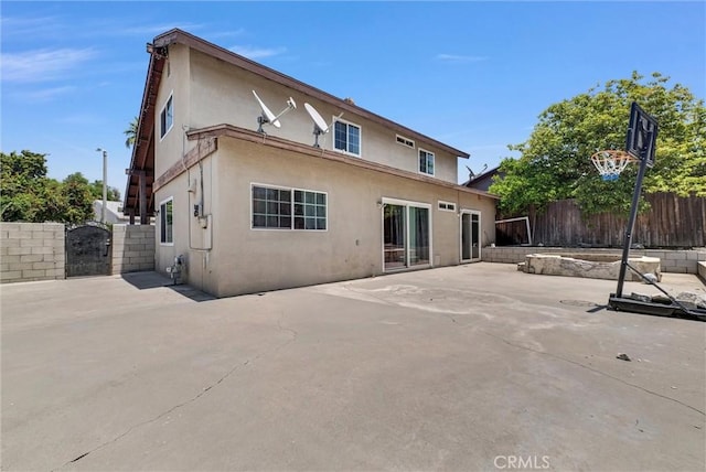 5005 Pearblossom Dr, Riverside, CA 92507 - rear view of property featuring stucco siding, a patio, and a gate