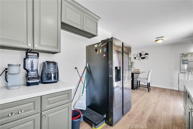 5005 Pearblossom Dr, Riverside, CA 92507 - kitchen with gray cabinetry, stainless steel fridge with ice dispenser, light wood-style floors, and light countertops