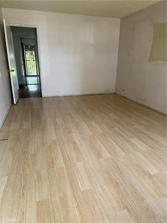 1317 S Baker St, Santa Ana, CA 92707 - empty room with light wood-type flooring and a textured ceiling