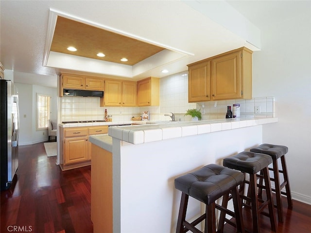 34 Via Capri, Rancho Palos Verdes, CA 90275 - kitchen featuring a tray ceiling, tile counters, freestanding refrigerator, a peninsula, and a kitchen bar