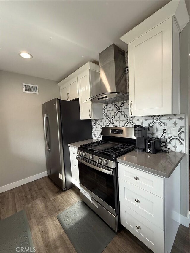 3935 W Mcfadden Ave Unit D, Santa Ana, CA 92704 - kitchen with appliances with stainless steel finishes, wall chimney exhaust hood, decorative backsplash, dark wood finished floors, and white cabinetry