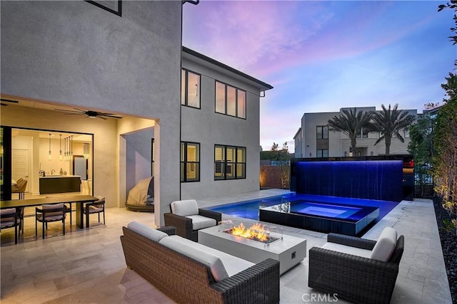 20211 W Liverpool Way, Porter Ranch, CA 91326 - patio terrace at dusk featuring a patio area, an outdoor living space with a fire pit, ceiling fan, an in-ground hot tub, and outdoor dining space