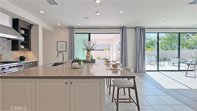80 Interstellar, Irvine, CA 92618 - kitchen featuring decorative backsplash, light tile patterned floors, wall chimney exhaust hood, white cabinets, and recessed lighting