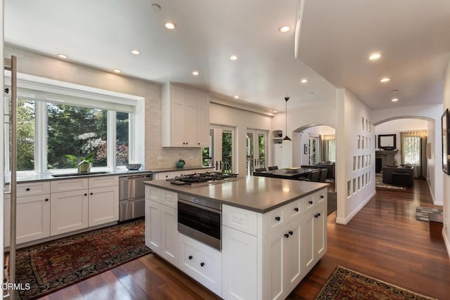 1040 Hillcroft Rd, Glendale, CA 91207 - kitchen with arched walkways, stainless steel appliances, a kitchen island, dark wood finished floors, and recessed lighting