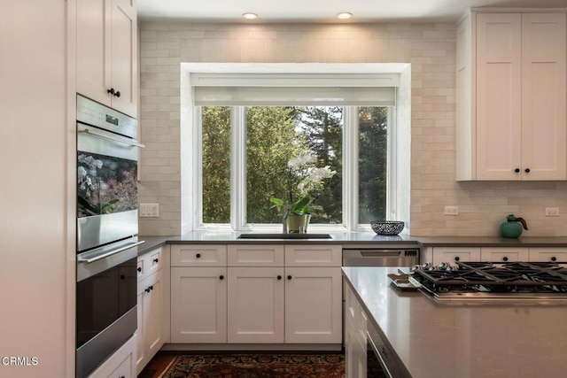 1040 Hillcroft Rd, Glendale, CA 91207 - kitchen featuring appliances with stainless steel finishes, tasteful backsplash, white cabinetry, and dark countertops