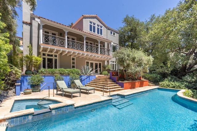 1040 Hillcroft Rd, Glendale, CA 91207 - rear view of house featuring a patio, a balcony, stucco siding, a pool with connected hot tub, and a tiled roof