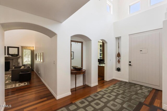 1040 Hillcroft Rd, Glendale, CA 91207 - entrance foyer featuring wood finished floors, a fireplace, a high ceiling, and arched walkways