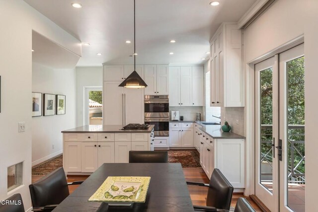 1040 Hillcroft Rd, Glendale, CA 91207 - kitchen with stainless steel appliances, white cabinets, tasteful backsplash, dark countertops, and recessed lighting