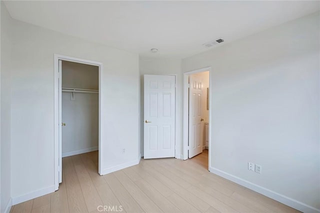 1211 E Carson St Unit 27, Carson, CA 90745 - unfurnished bedroom featuring light wood-type flooring, a spacious closet, and a closet